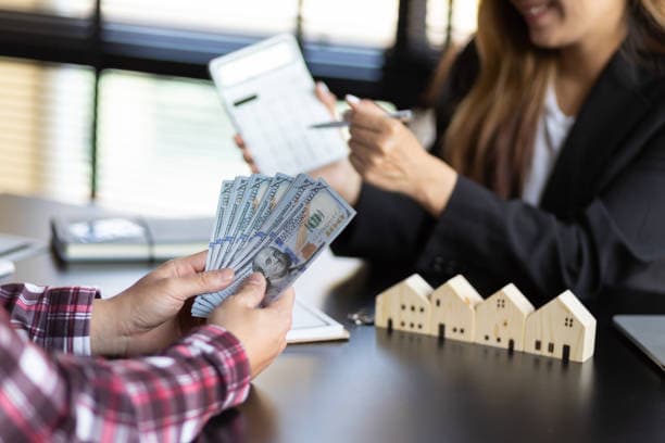 A couple reviewing mortgage paperwork with a loan officer at a desk